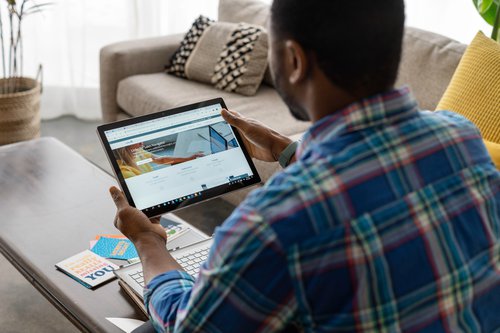 Back of a person looking at a tablet screen displaying LinkedIn