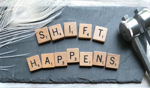 "Shift Happens" written with Scrabble Tiles